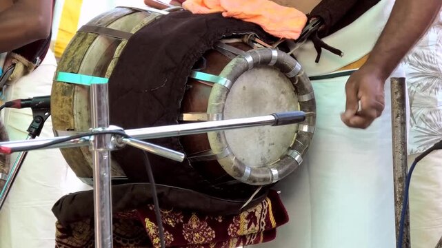 Closeup of an artist playing Thavil (Thakil), a South Indian percussion musical instrument, during the festival celebration in a temple in Kerala, India