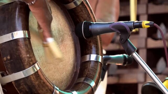 Closeup of an artist playing Thavil (Thakil), a South Indian percussion musical instrument, during the festival celebration in a temple in Kerala, India