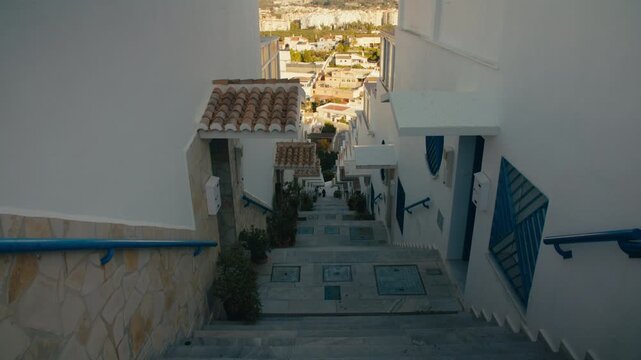 Narrow white stairway with blue shutters leading down to the town of Almu&ntilde;&eacute;car on the Costa Tropical in southern Spain.