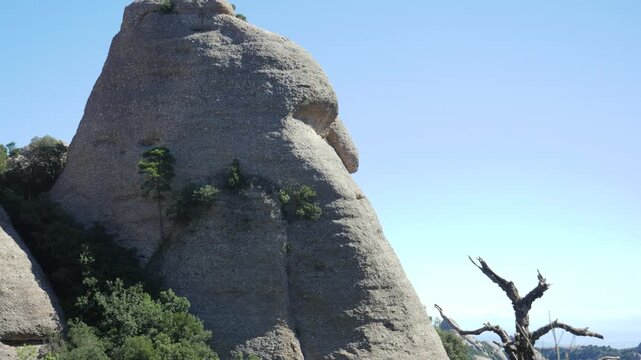 A natural rock formation in Montserrat resembling a human face in profile. The "Forehead," "nose," and "chin" are clearly visible against a bright blue sky.
