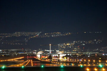 伊丹空港の夜、光の川を走り離陸開始するプロペラ機 © maruboland