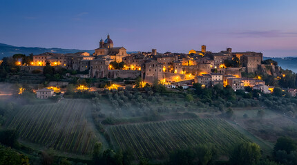 Obraz premium Illuminated Hilltop Village in Tuscany at Sunset with Rolling Vineyards