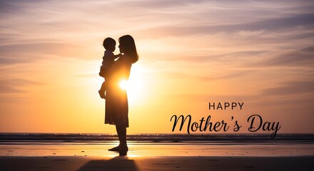Silhouette of mother holding baby on beach at sunset with happy mothers day text vibrant sky