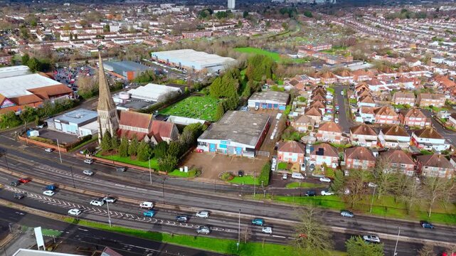aerial drone shot high angle over the Millbrook suburban housing area estate in Southampton at sunset with trees, homes and nature surrounding. Shot in winter with traffic and cars driving the streets
