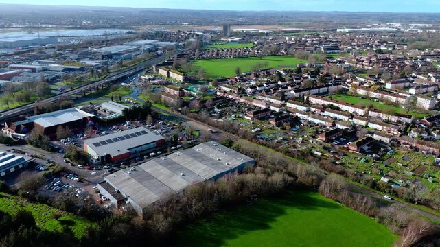 aerial drone shot high angle over the Millbrook suburban housing area estate in Southampton at sunset with trees, homes and nature surrounding. Shot in winter with traffic and cars driving the streets