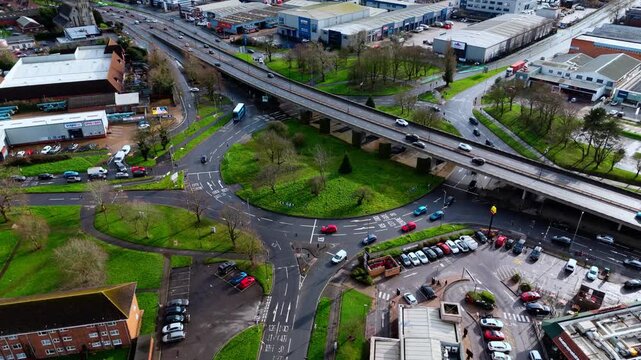aerial Birds Eye overhead shot over the Millbrook flyover roundabout in Southampton, Hampshire, England. Shot at sunset in winter with bright light shining as the cars pass over the industrial suburb.