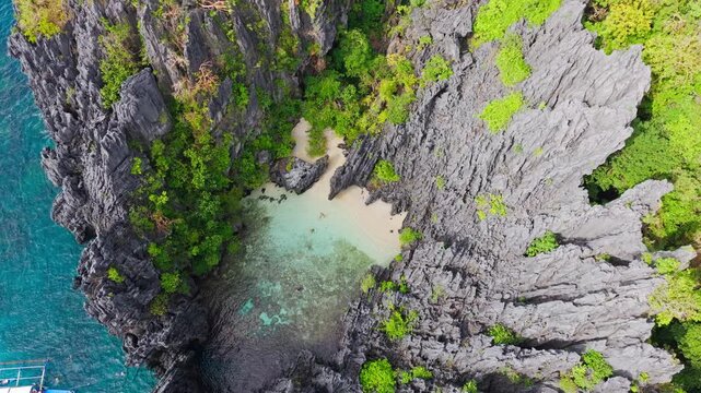 Dynamic tilt down to hidden lagoon then soaring upward above cliffs