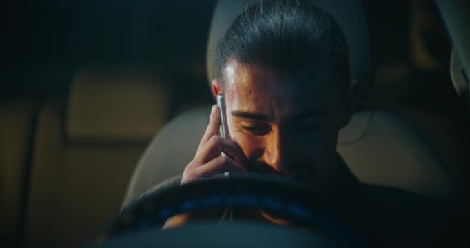 Smiling Male Driver Talks on Phone While Sitting in Car. Man Laughs Openly, Clearly Engaged in Pleasant Conversation. Concept Casual Communication, Good Mood, Everyday Connection in Modern Setting.