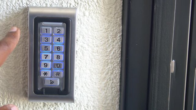 Hand enters code on numeric keypad for access