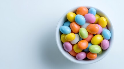 Obraz premium An overhead view shows many pastel Jordan almonds clustered inside a small white.