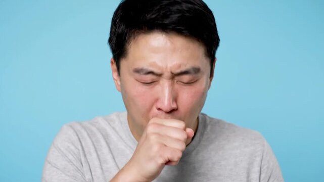 High quality realistic medium close video of person experiencing cough covering mouth with hand subtle discomfort expression soft flushed nose area natural breathing cycle slight shoulder movement cle