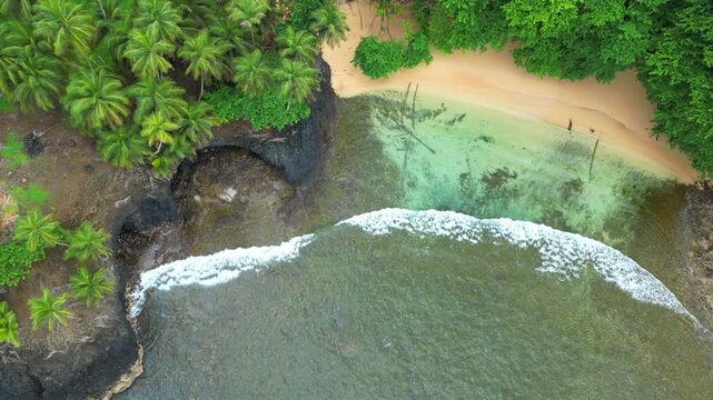 Aerial descending view over the piscina beach and its transparent sea at the south of the S&atilde;o Tom&eacute; island,AFrica