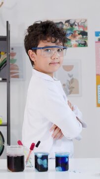Young Asian Boy in Lab Coat Posing Proudly with Science Experiment