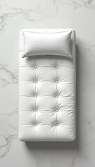Fototapeta premium Top view of white futon mattress with button tufts and a pillow on marble surface. Simple clean design suitable for modern bedroom or lounge.