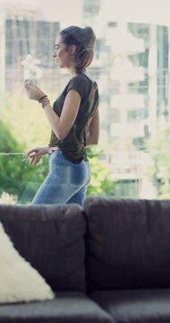 Balcony, coffee and windy with woman in studio apartment for break, city view or morning wellness. Breeze, cup and relax with happy person drinking beverage in urban home for start of weekend