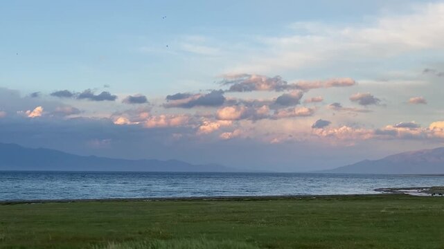 A tranquil shoreline along Sayram Lake rests beneath the towering Tianshan mountains in Xinjiang&rsquo;s Bortala Prefecture.