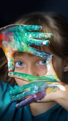 Vertical close-up of colorful painted hands framing girl's eyes for artistic expression and social media © Vera Kuttelvaserova