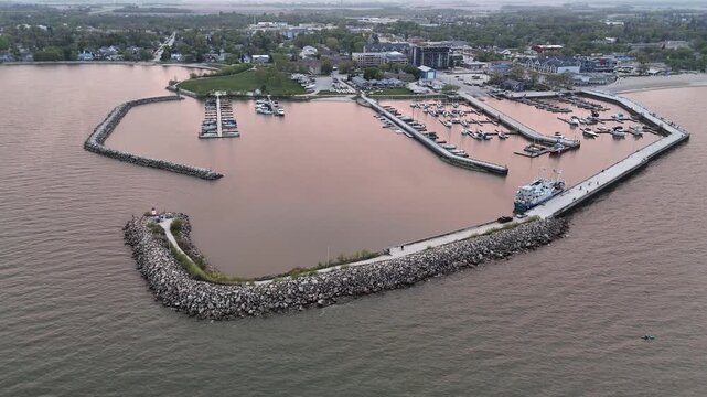 Drone aerial over Lake Winnipeg at Gimli Harbour, Manitoba, facing the town while slowly rotating right. Scenic waterfront marina and shoreline in the New Iceland community.