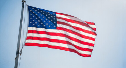 Obraz premium American flag waving against clear blue sky 
