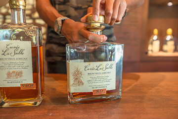 Fototapeta premium Sainte-Marie, Martinique, French Antilles - Dec 27, 2025: Customer enjoying a rhum tasting experience at Habitation La Salle distillery in Sainte-Marie, Martinique, French Antilles.