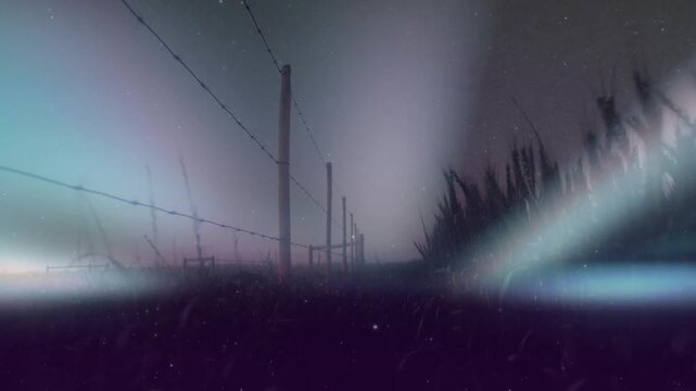 Camera drifting forward along barbed fence, haze lifting, grass sharpening, glow revealing horizon