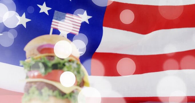 Camera pushing, stacked cheeseburger rising, mini US flag centering, bokeh drifting evoking pride