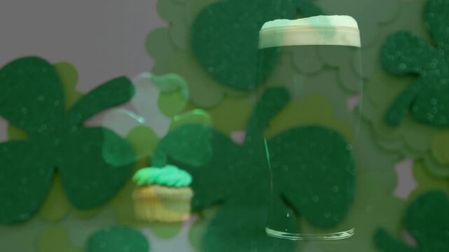 Camera revealing cupcake and pint glass, shamrock cutouts drifting forward to create festive reveal