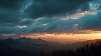 Fototapeta premium Dramatic mountain range at sunset with stormy colorful clouds casting a moody glow over layered peaks