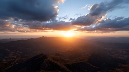 Obraz premium Dramatic sunset illuminates rugged mountain landscape with golden light