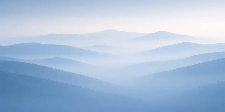 Misty mountain landscape at sunrise with heavy fog and clouds rolling over the forest valley and blue hills under a glowing morning sky