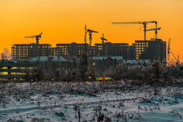 Photo of construction tower crane at winter sunset