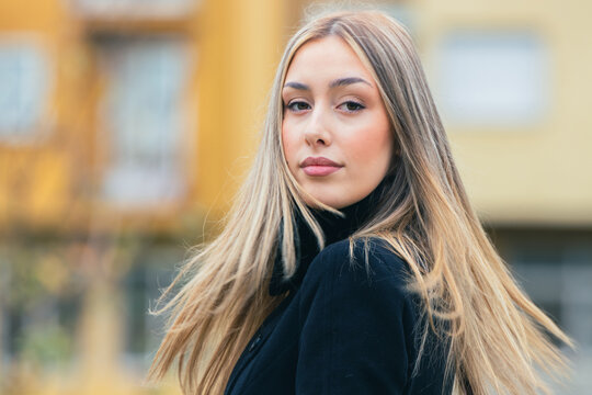 portrait of a young woman with long blonde hair on the street
