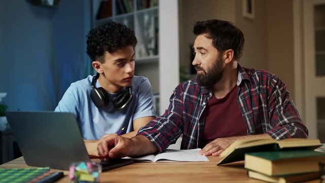 Father helps teenage son to solve math equations, parental support, togetherness
