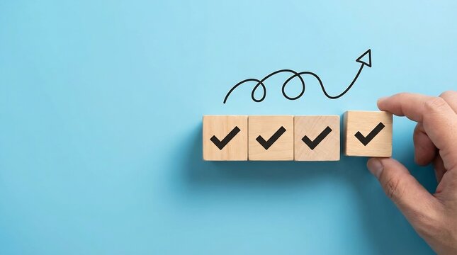 Hand positions a fourth wooden block featuring a black check symbol beside three preceding blocks, symbolizing task finalization on a light blue backdrop.