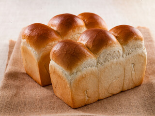 Mountain-shaped White Bread (식빵) with three golden domes on rustic burlap. © n3moh3ro