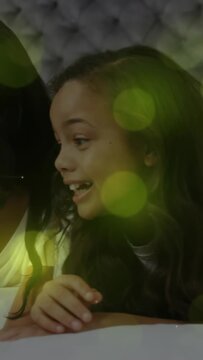 Vertical video: Mom and daughter lying on bed mom bringing phone sharing tech with green overlay