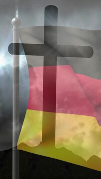 Vertical video: Wind driving flag waving and folding, cross fixed, light flaring to convey storm