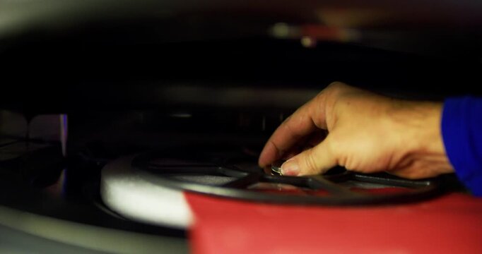 Turntable of pizza oven being removed and replaced by man's hand - closeup