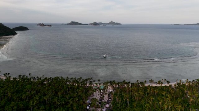 Drone aerial view of Bayang Basecamp or Calibangbangan Camp and turquoise reef along Calibangbangan Island coastline between Coron and El Nido, Palawan, Philippines.