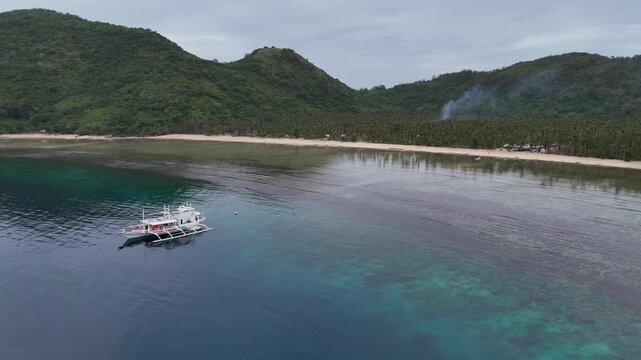 Drone aerial view of Bayang Basecamp or Calibangbangan Camp and turquoise reef along Calibangbangan Island coastline between Coron and El Nido, Palawan, Philippines.