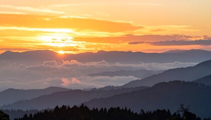 Obraz premium Golden Sunrise Over Misty Mountain Peaks with Sun Rays.