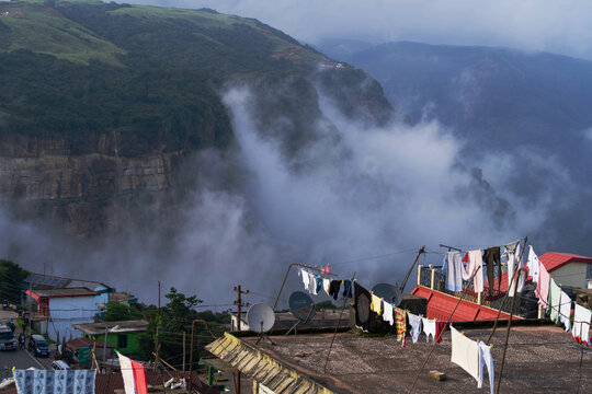 Cherrapunji, India - 24 July 2023: View of clothes hanging on rooftops against a backdrop of misty hills, creating a striking contrast between everyday life and majestic nature.