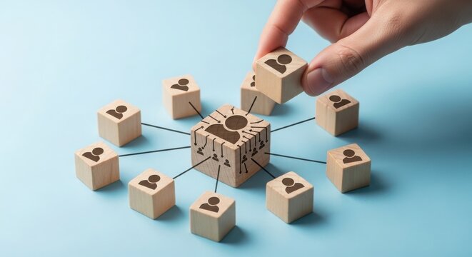A hand strategically connecting wooden blocks in a network formation