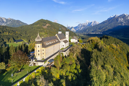 Aerial view of the Frauenberg Pilgrimage Church perched atop a hill, its pale walls contrasting with the surrounding verdant forest, Wallfahrtskirche Frauenberg an der Enns, Steiermark, Austria.