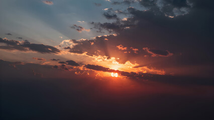 Obraz premium Vibrant sunset sky with diagonal colors, dynamic movement, and partially hidden sun behind wispy clouds