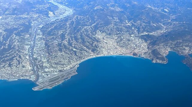 Elevated aerial view of Nice airport and city taken from a jet cockpit flying at 12000m high in a winter sunny day.