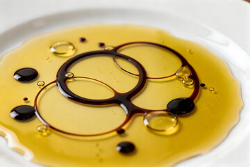Culinary Harmony: A close-up shot of a plate elegantly adorned with a swirl of rich olive oil and balsamic glaze, inviting culinary exploration and flavor discovery.