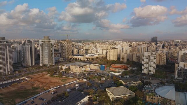 Holon city panorama including Breeza Pool and the Mediatheque complex captured with a wide aerial orbit, Israel.