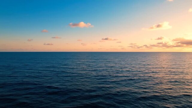 Beautiful tranquil ocean surface under a vibrant sunset sky with clouds