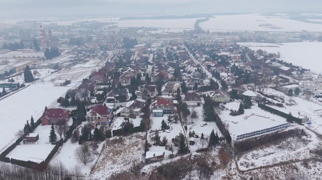 Aerial winter scene of modern family homes in city.
Snowy luxury neighborhood from drone perspective.
